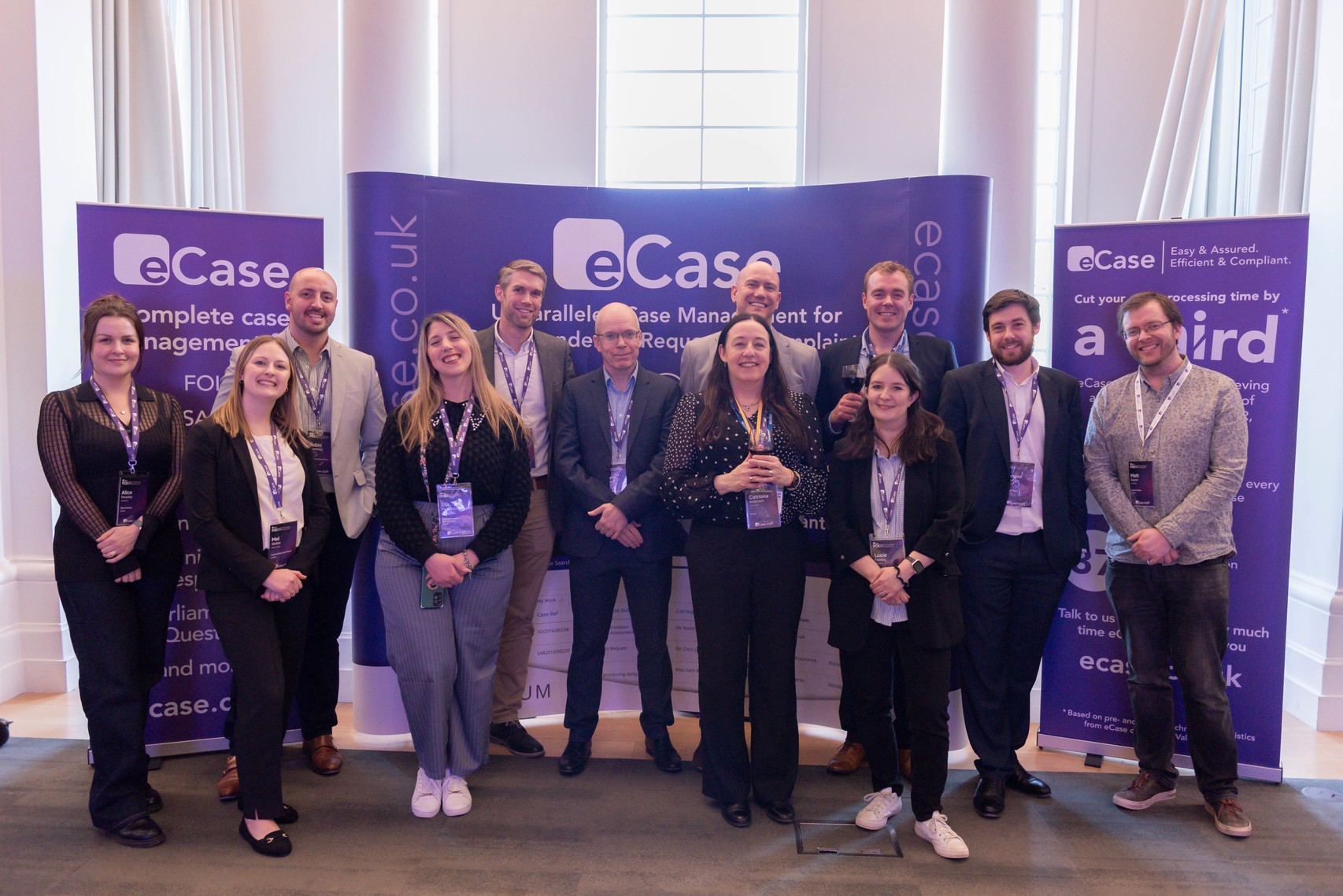 The Fivium team standing in front of eCase banners