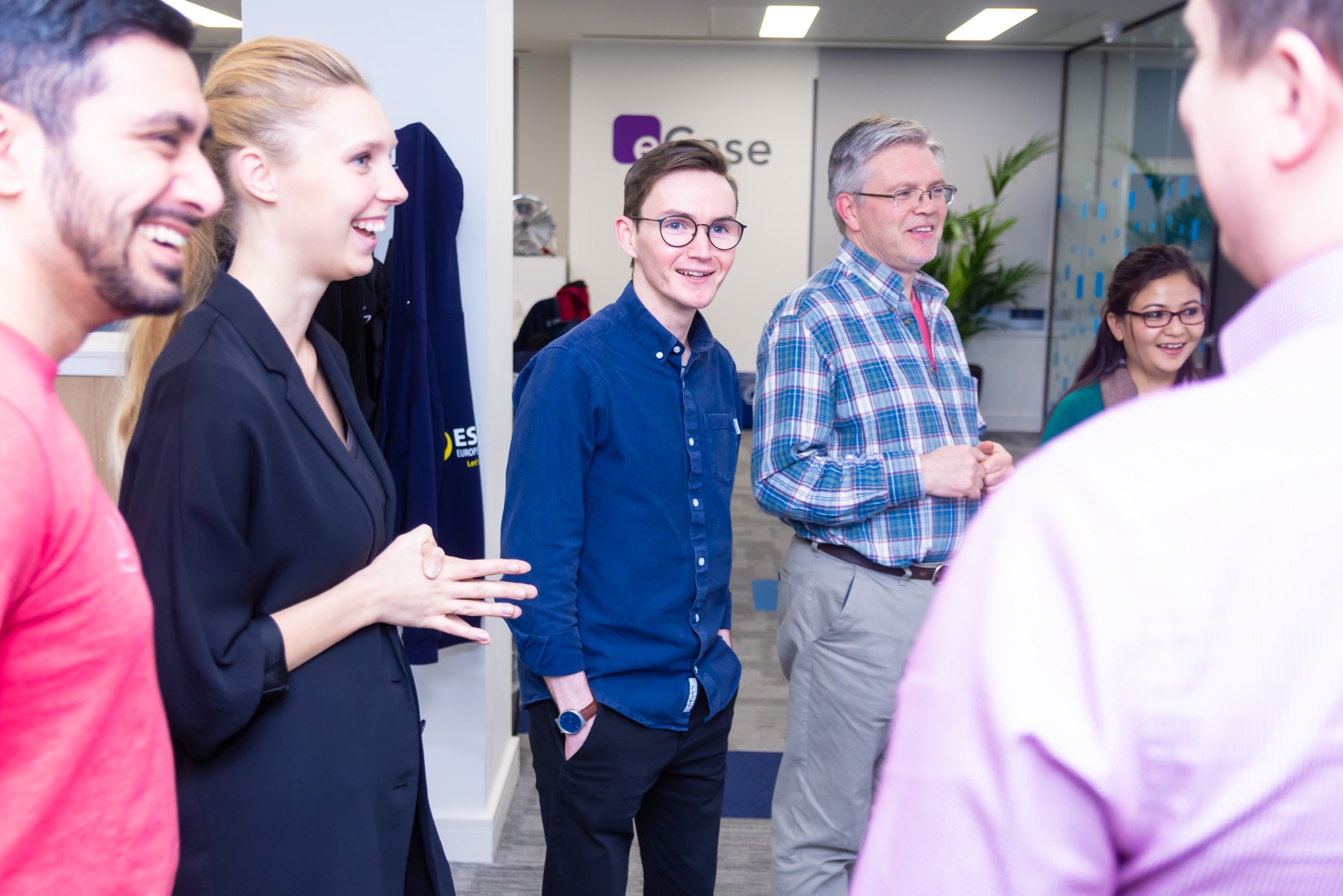 Staff standing in a group in the office smiling