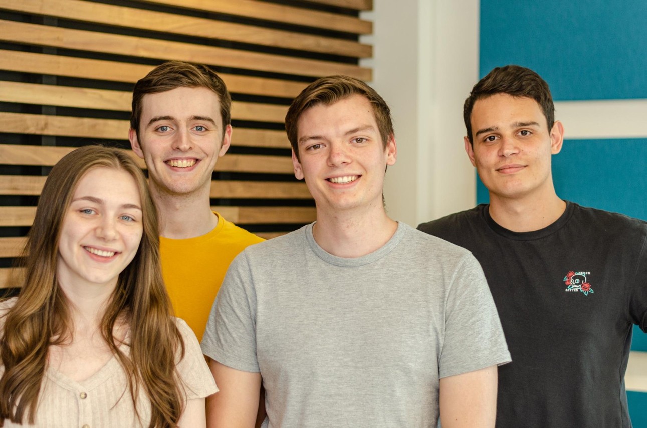 Four smiling students facing the camera